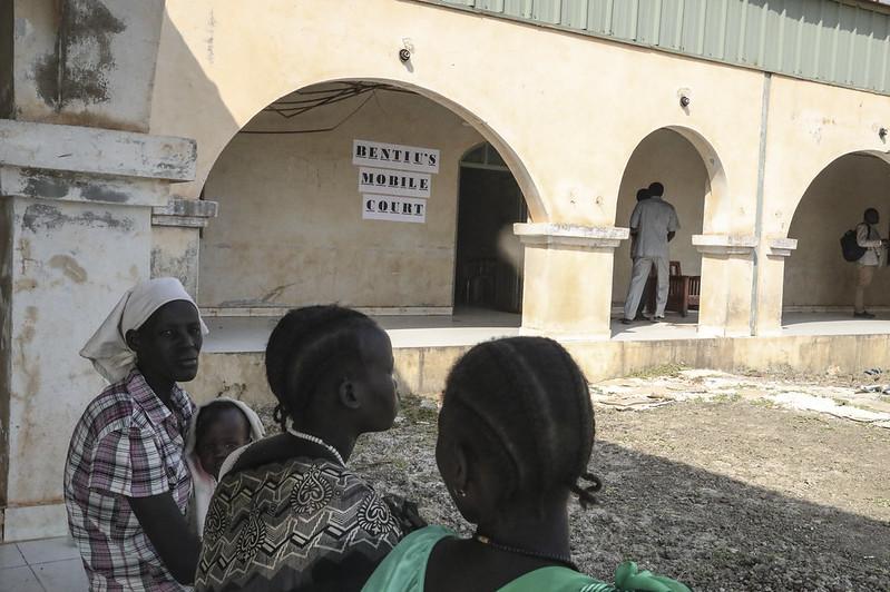 Women sitting on a bench in front of Bentiu's mobile court