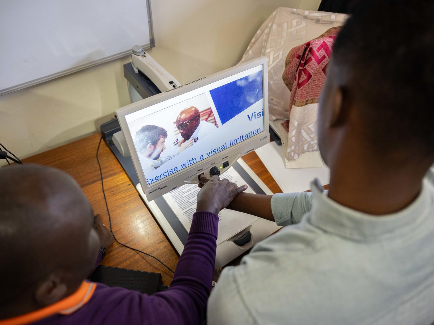 Photo of Abdirahman Mohamud Kulane, inspects one of the assistive tools during a week-long training on braille production and digital inclusion at KyU Hi-Techn Center in Kampala, Uganda.